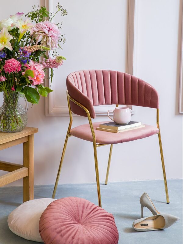 Różowe tapicertowane krzesło ze złotymi nogami